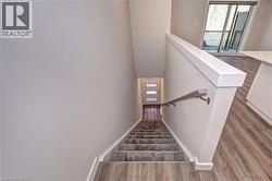 Stairs with wood finished floors and baseboards -