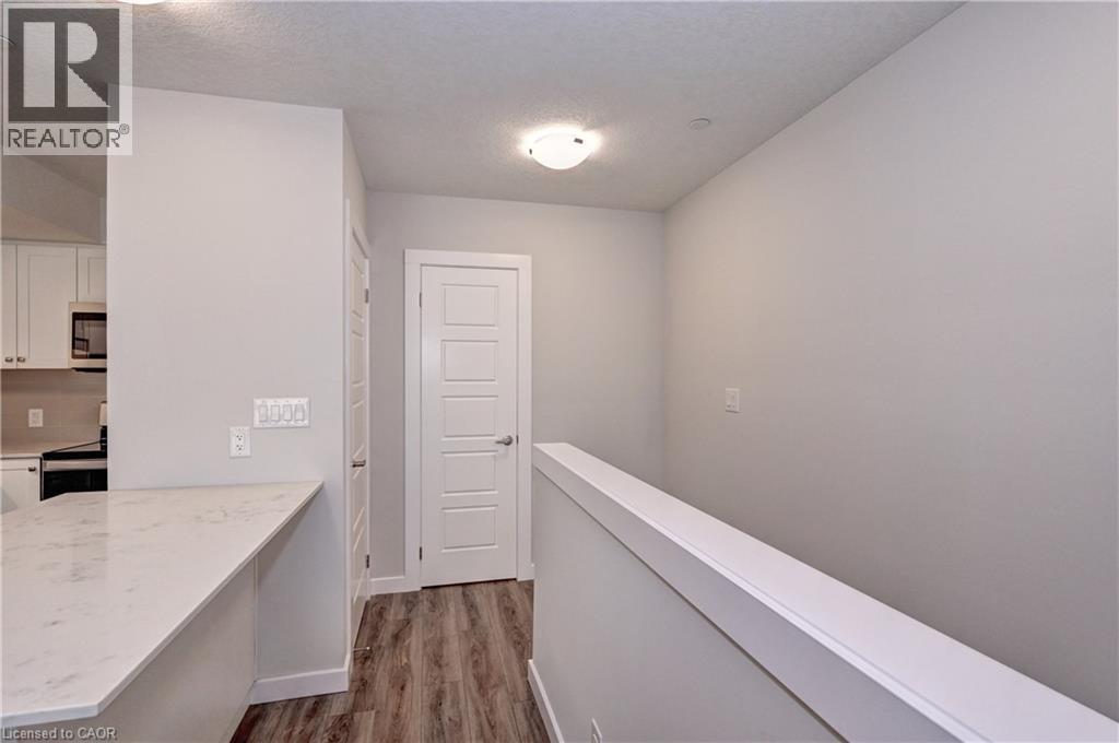 Corridor featuring dark wood-style floors and a textured ceiling - 118 Gravel Ridge Trail Unit# C17, Kitchener, ON - Indoor Photo Showing Other Room