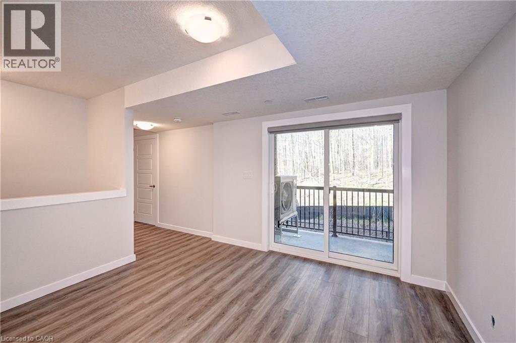 Unfurnished room featuring a textured ceiling and wood finished floors - 118 Gravel Ridge Trail Unit# C17, Kitchener, ON - Indoor Photo Showing Other Room