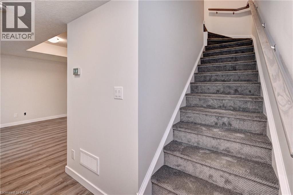 Stairway featuring wood finished floors and a textured ceiling - 118 Gravel Ridge Trail Unit# C17, Kitchener, ON - Indoor Photo Showing Other Room