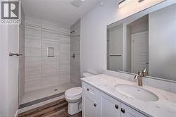 Full bathroom with a shower stall, vanity, and dark wood-type flooring -