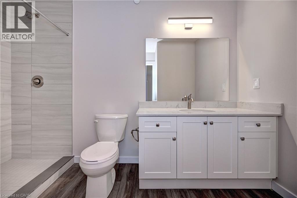 Full bathroom featuring a shower stall, vanity, and dark wood-type flooring - 118 Gravel Ridge Trail Unit# C17, Kitchener, ON - Indoor Photo Showing Bathroom