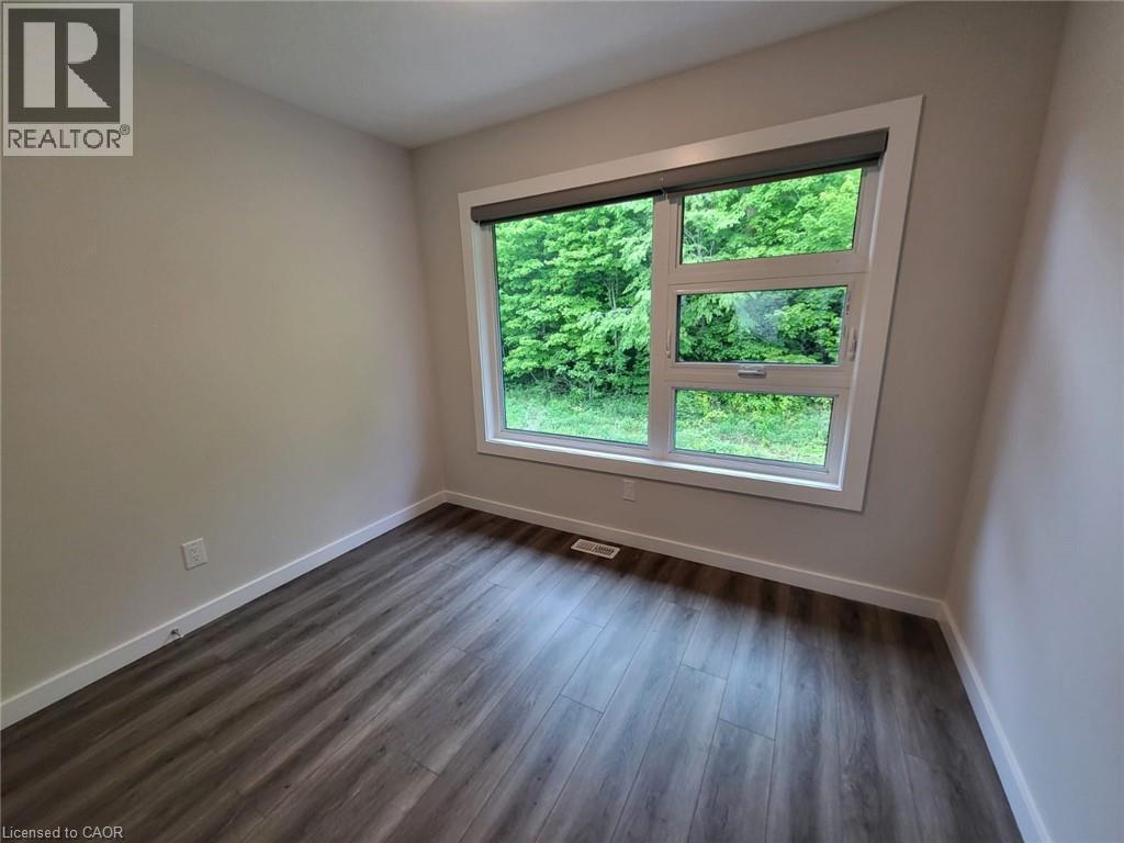 Unfurnished room with baseboards and dark wood-style floors - 118 Gravel Ridge Trail Unit# B23, Kitchener, ON - Indoor Photo Showing Other Room