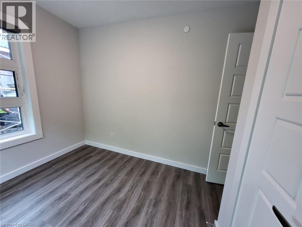 Spare room with dark wood-type flooring and baseboards - 118 Gravel Ridge Trail Unit# B23, Kitchener, ON - Indoor Photo Showing Other Room