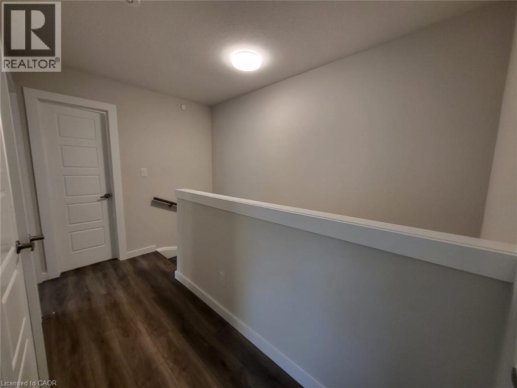Hall with an upstairs landing and dark wood-style floors - 118 Gravel Ridge Trail Unit# B23, Kitchener, ON - Indoor Photo Showing Other Room