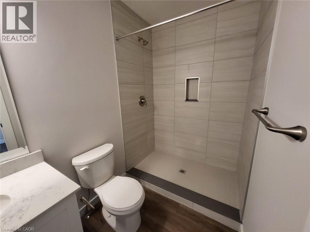 Full bathroom with a stall shower, vanity, and dark wood-type flooring - 118 Gravel Ridge Trail Unit# B23, Kitchener, ON - Indoor Photo Showing Bathroom