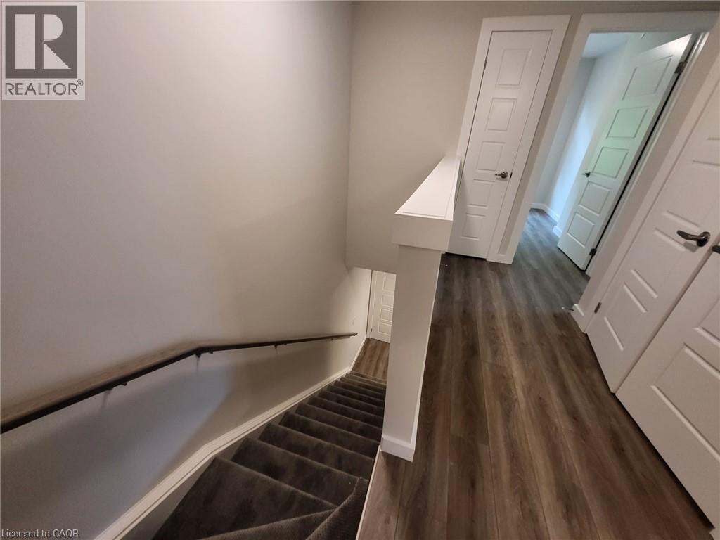 Stairway featuring baseboards and wood finished floors - 118 Gravel Ridge Trail Unit# B23, Kitchener, ON - Indoor Photo Showing Other Room