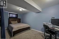 Bedroom featuring light colored carpet and an office area -
