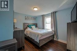 Bedroom with dark wood-type flooring -