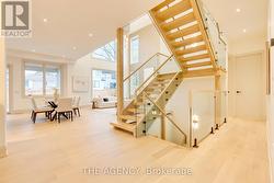 Floating wood/glass staircase with skylight above -