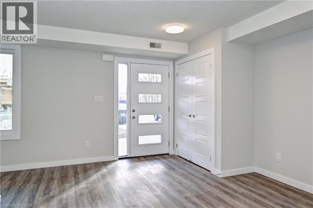 Foyer entrance featuring wood finished floors and plenty of natural light - 118 Gravel Ridge Trail Unit# G21, Kitchener, ON - Indoor Photo Showing Other Room