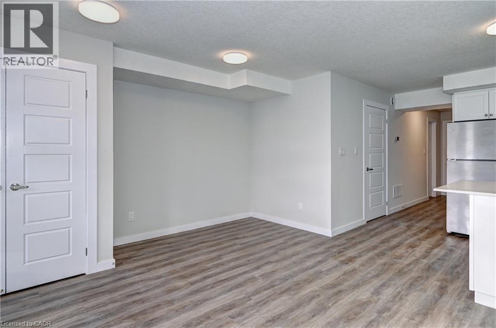 Empty room featuring a textured ceiling and light wood finished floors - 118 Gravel Ridge Trail Unit# G21, Kitchener, ON - Indoor Photo Showing Other Room