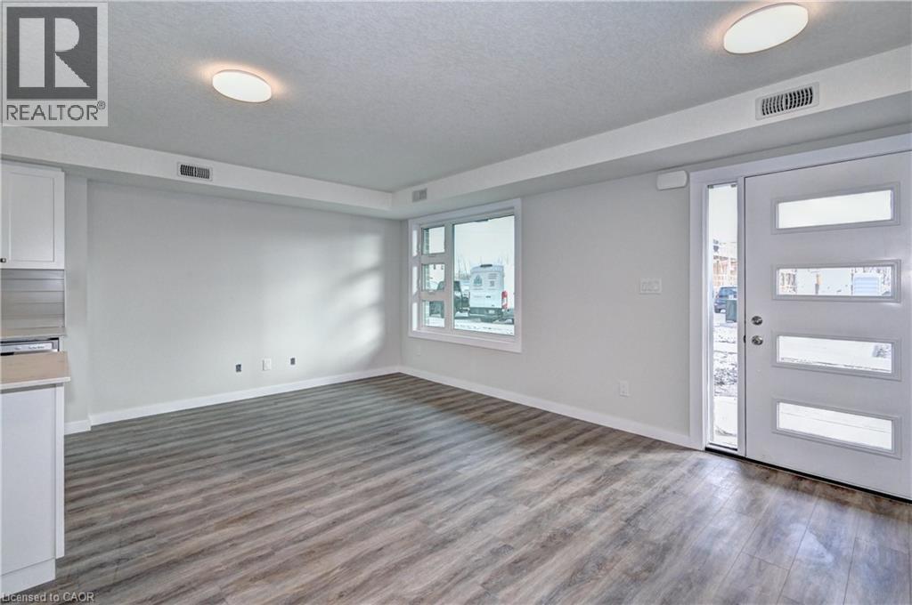 Foyer entrance featuring a textured ceiling and dark wood-style floors - 118 Gravel Ridge Trail Unit# G21, Kitchener, ON - Indoor Photo Showing Other Room