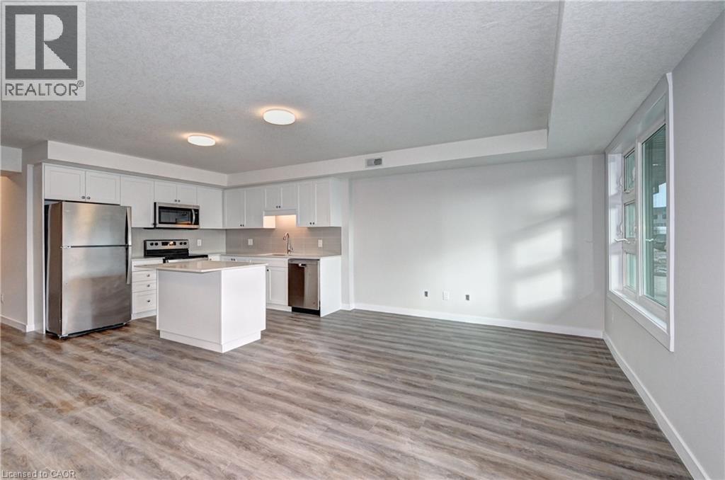Kitchen featuring appliances with stainless steel finishes, light countertops, white cabinets, a textured ceiling, and light wood finished floors - 118 Gravel Ridge Trail Unit# G21, Kitchener, ON - Indoor Photo Showing Kitchen