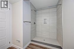 Full bathroom with a stall shower and wood finished floors -