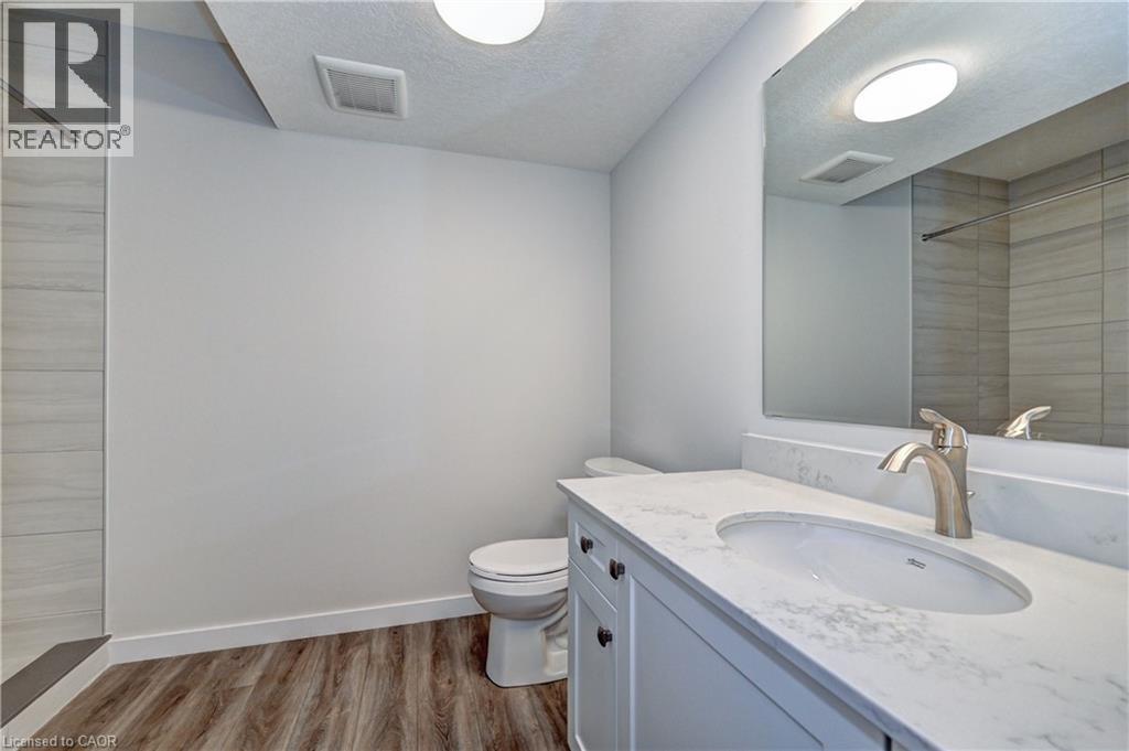 Full bathroom with tiled shower, vanity, light wood finished floors, and a textured ceiling - 118 Gravel Ridge Trail Unit# G21, Kitchener, ON - Indoor Photo Showing Bathroom