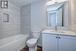 Full bath featuring vanity, shower / washtub combination, and dark wood finished floors -