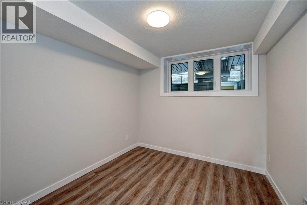 Unfurnished room with a textured ceiling and wood finished floors - 118 Gravel Ridge Trail Unit# G21, Kitchener, ON - Indoor Photo Showing Other Room