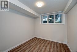 Unfurnished room with a textured ceiling and wood finished floors -