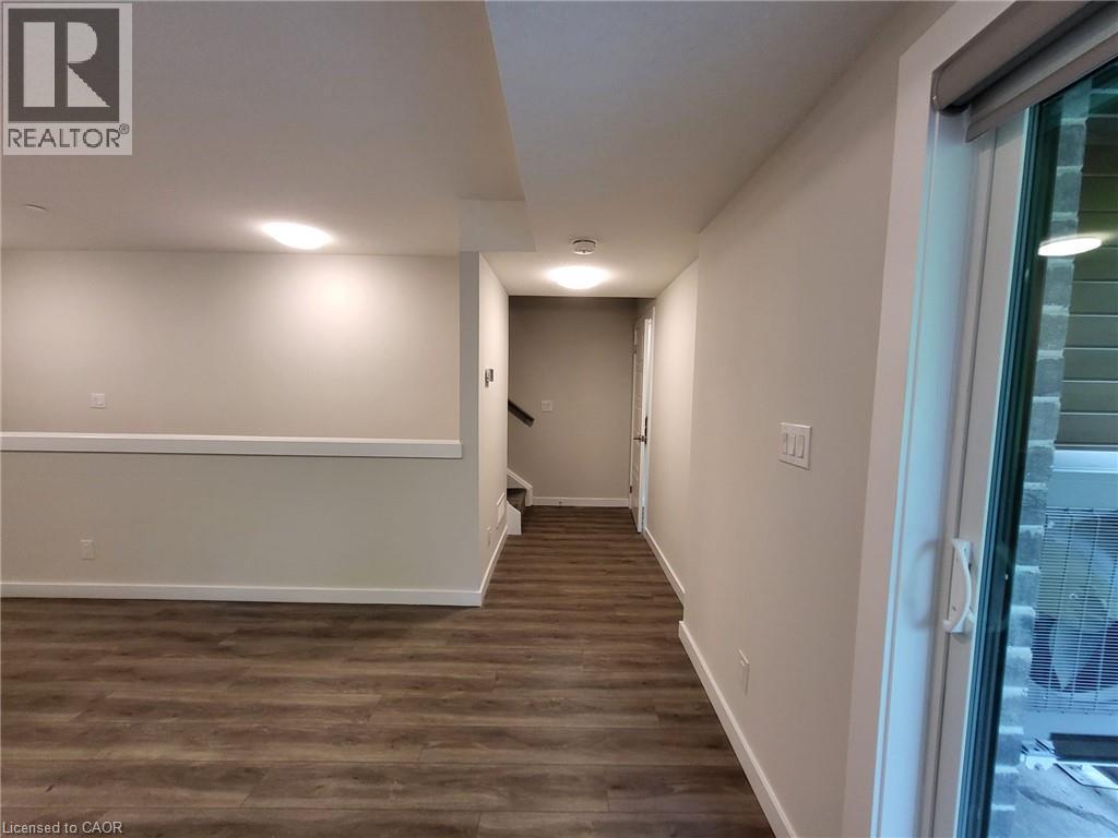 Basement with dark wood-style floors and stairs - 118 Gravel Ridge Trail Unit# F17, Kitchener, ON - Indoor Photo Showing Other Room