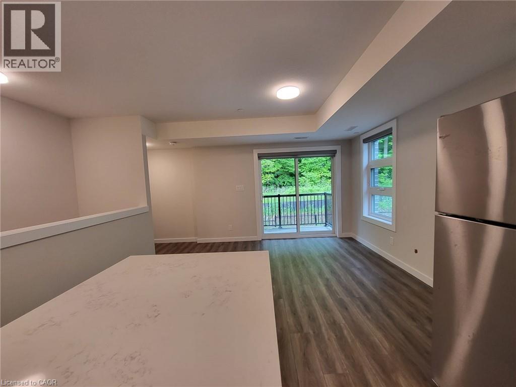 Kitchen featuring freestanding refrigerator and dark wood-style flooring - 118 Gravel Ridge Trail Unit# F17, Kitchener, ON - Indoor Photo Showing Other Room