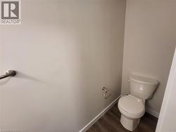 Bathroom featuring baseboards and dark wood-style flooring -