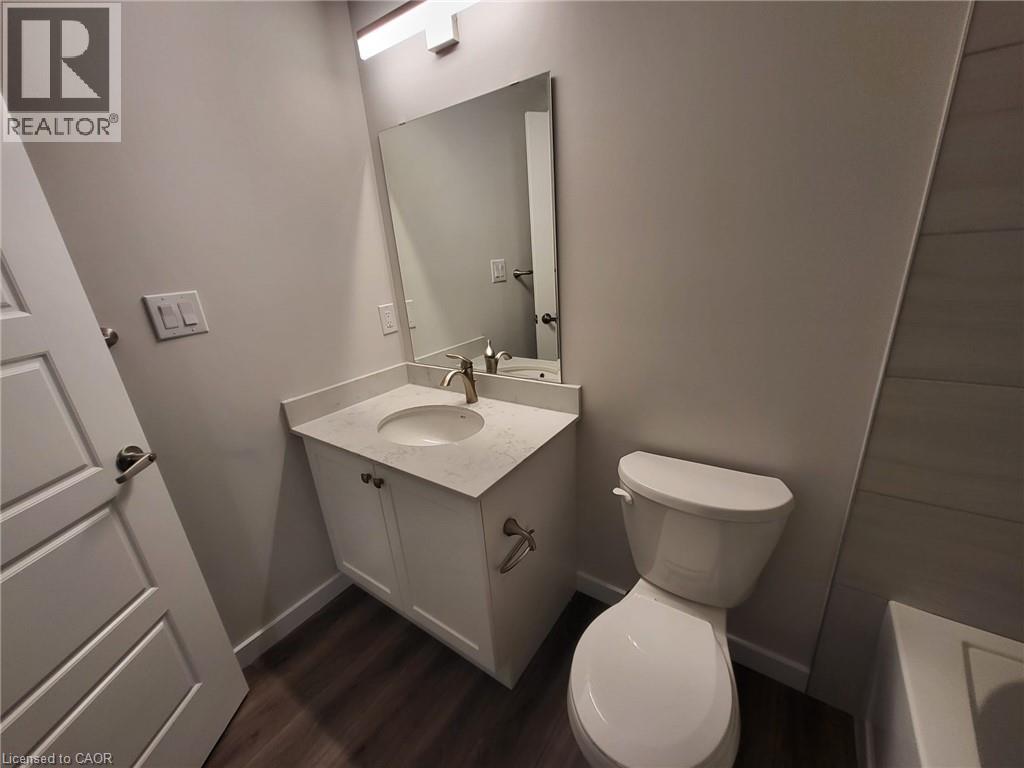 Bathroom with vanity, a bathtub, and dark wood-type flooring - 118 Gravel Ridge Trail Unit# F17, Kitchener, ON - Indoor Photo Showing Bathroom