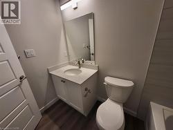 Bathroom with vanity, a bathtub, and dark wood-type flooring -