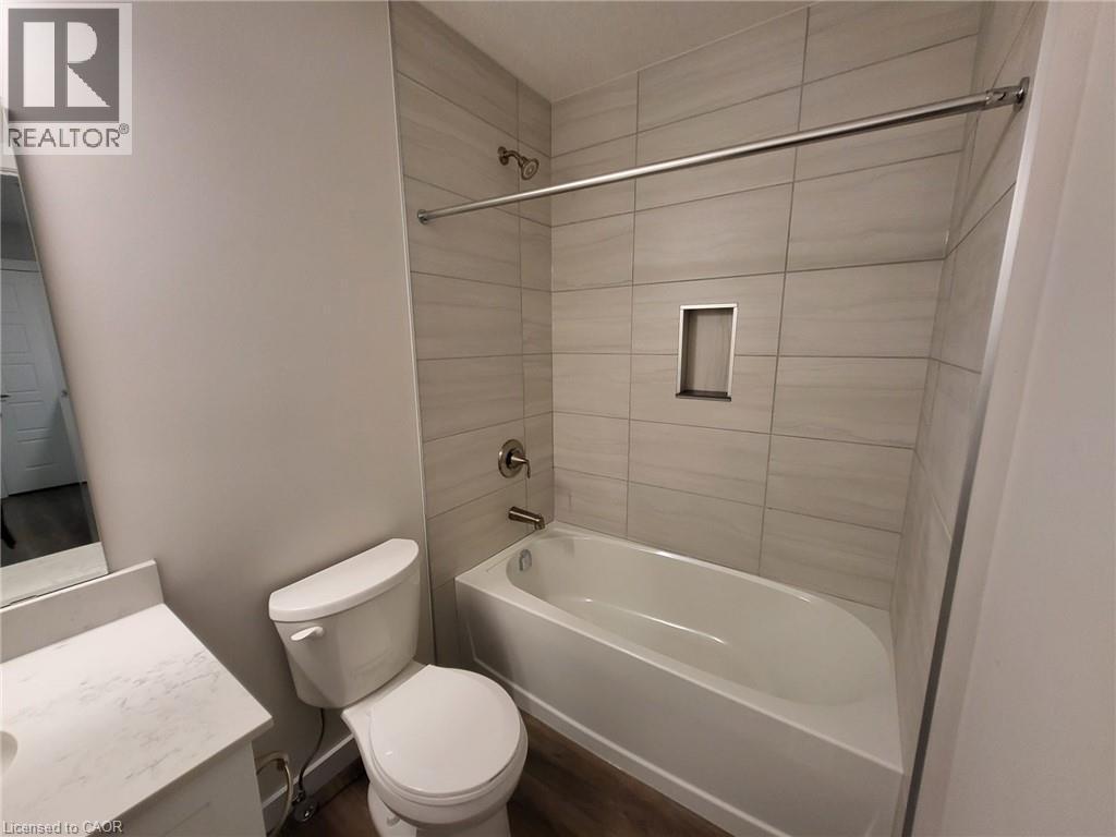 Bathroom with vanity, tub / shower combination, and dark wood finished floors - 118 Gravel Ridge Trail Unit# F17, Kitchener, ON - Indoor Photo Showing Bathroom