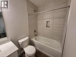 Bathroom with vanity, tub / shower combination, and dark wood finished floors -