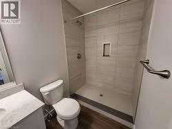 Full bathroom with a stall shower, vanity, and dark wood-type flooring -