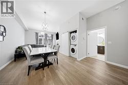 Dining space featuring light wood-style floors and stacked washer / dryer -