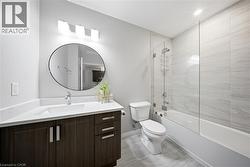 Bathroom with vanity and bath / shower combo with glass door -