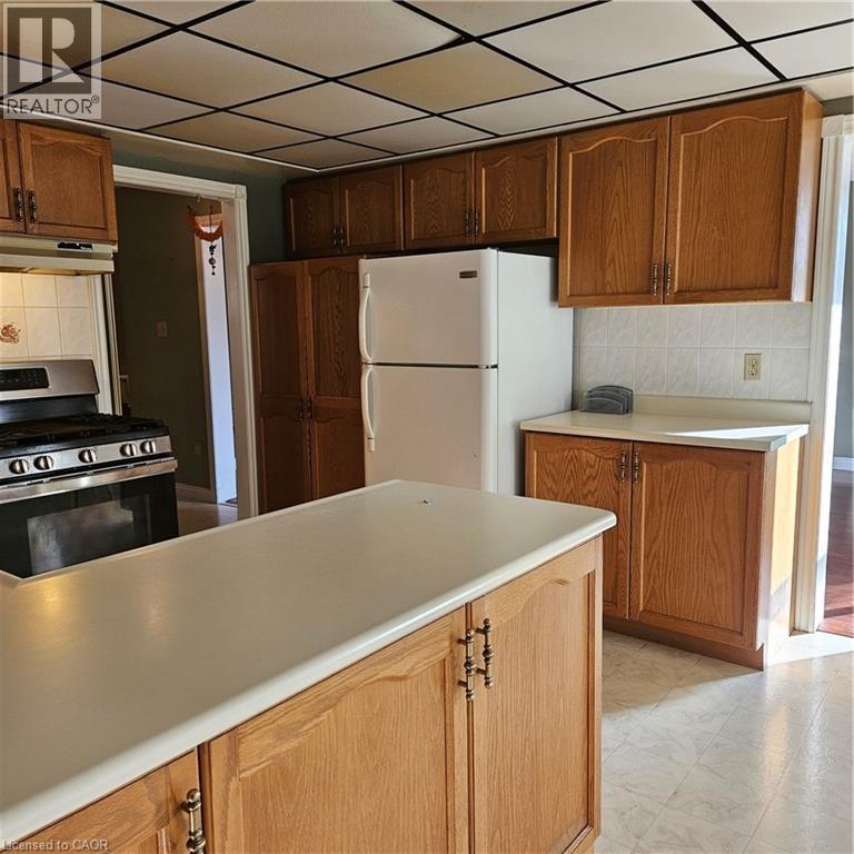 Kitchen with a drop ceiling, tasteful backsplash, range, white fridge, and exhaust hood - 115 Cranston Avenue, Cambridge, ON - Indoor Photo Showing Kitchen