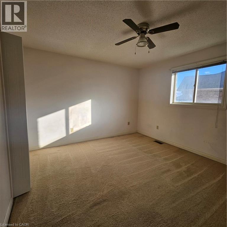 Carpeted spare room with a textured ceiling and ceiling fan - 115 Cranston Avenue, Cambridge, ON - Indoor Photo Showing Other Room