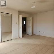 Unfurnished bedroom with a textured ceiling, a closet, and carpet -