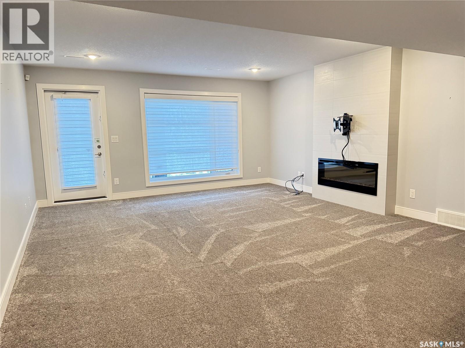 21 103 Pohorecky Crescent, Saskatoon, SK - Indoor Photo Showing Other Room With Fireplace