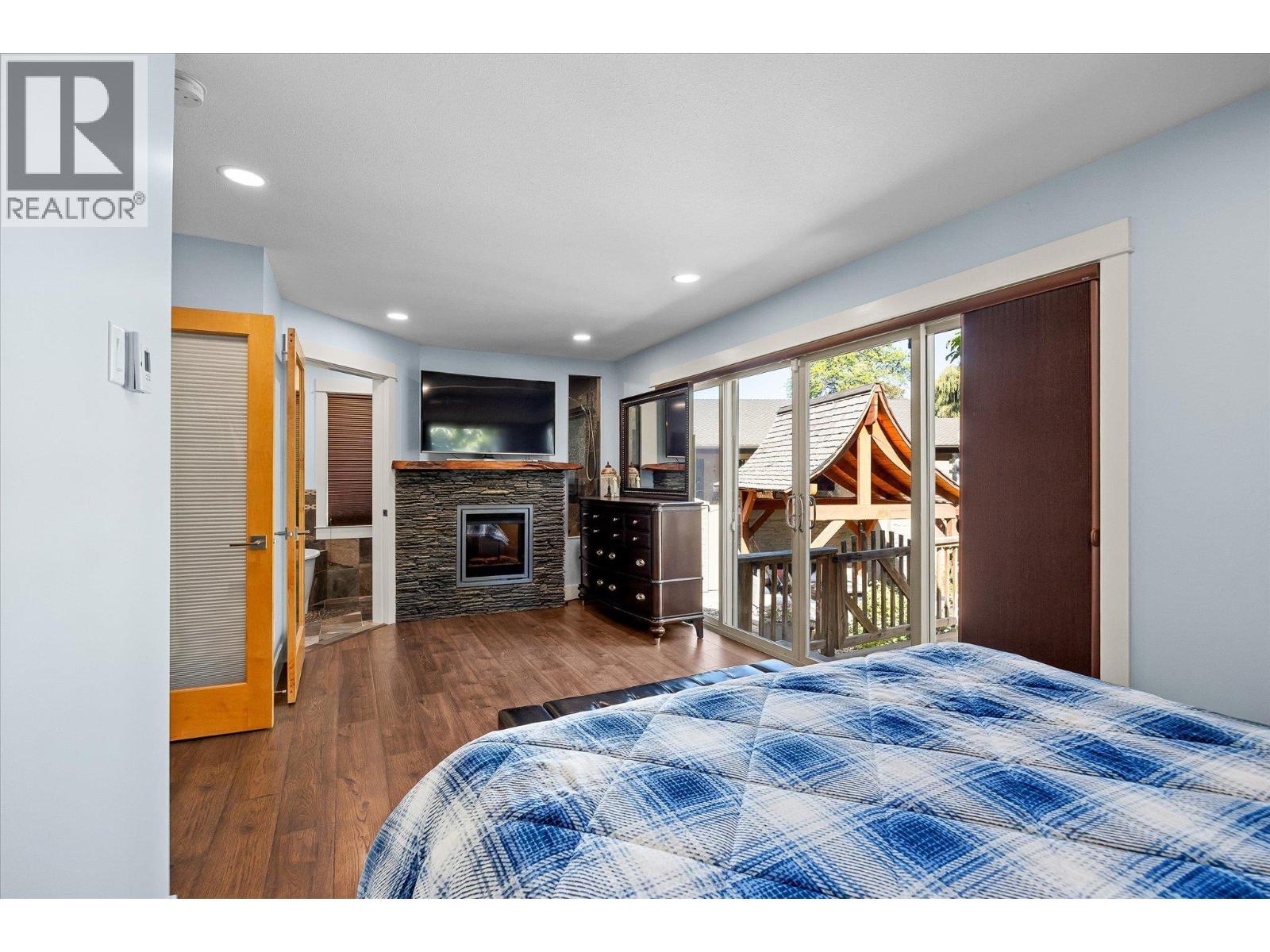 12313 Kalavista Drive, Coldstream, BC - Indoor Photo Showing Bedroom With Fireplace