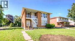 Traditional-style home featuring a front yard, brick siding, and a balcony -