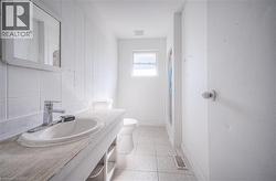 Full bathroom featuring a shower stall, vanity, light tile patterned floors, and tile walls -