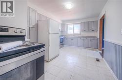 Kitchen with stainless steel electric range oven, light countertops, stainless steel stove, light tile patterned floors, and gray cabinets -