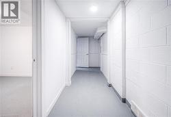 Hall featuring concrete floors, a wall unit AC, and concrete block wall -