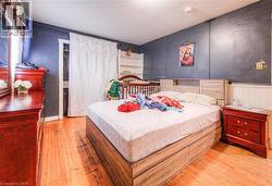 Bedroom featuring light wood finished floors and a decorative wall -