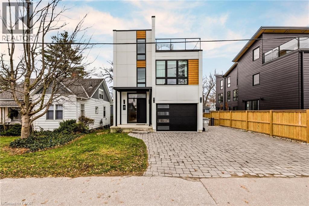 Contemporary home with decorative driveway, and a garage - 26 Huron Street, Grand Bend, ON - Outdoor