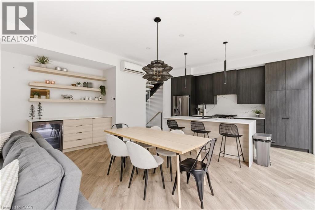 Dining area featuring stairs, beverage cooler, light wood finished floors, and a wall unit AC - 26 Huron Street, Grand Bend, ON - Indoor