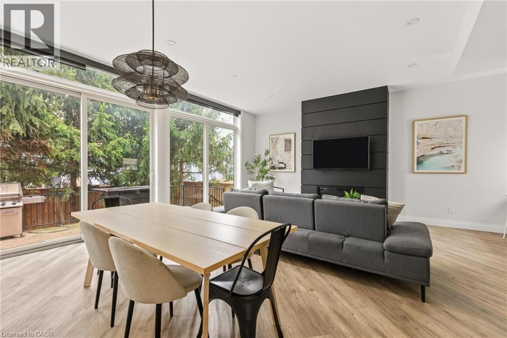 Dining room featuring a wall of windows and light wood finished floors - 26 Huron Street, Grand Bend, ON - Indoor