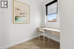 Office area featuring built in desk and light wood finished floors -