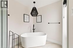 Full bath featuring a freestanding bath and light wood finished floors -