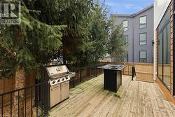 Wooden deck featuring area for grilling -