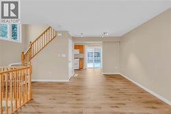 Unfurnished living room featuring light wood finished floors and stairs -